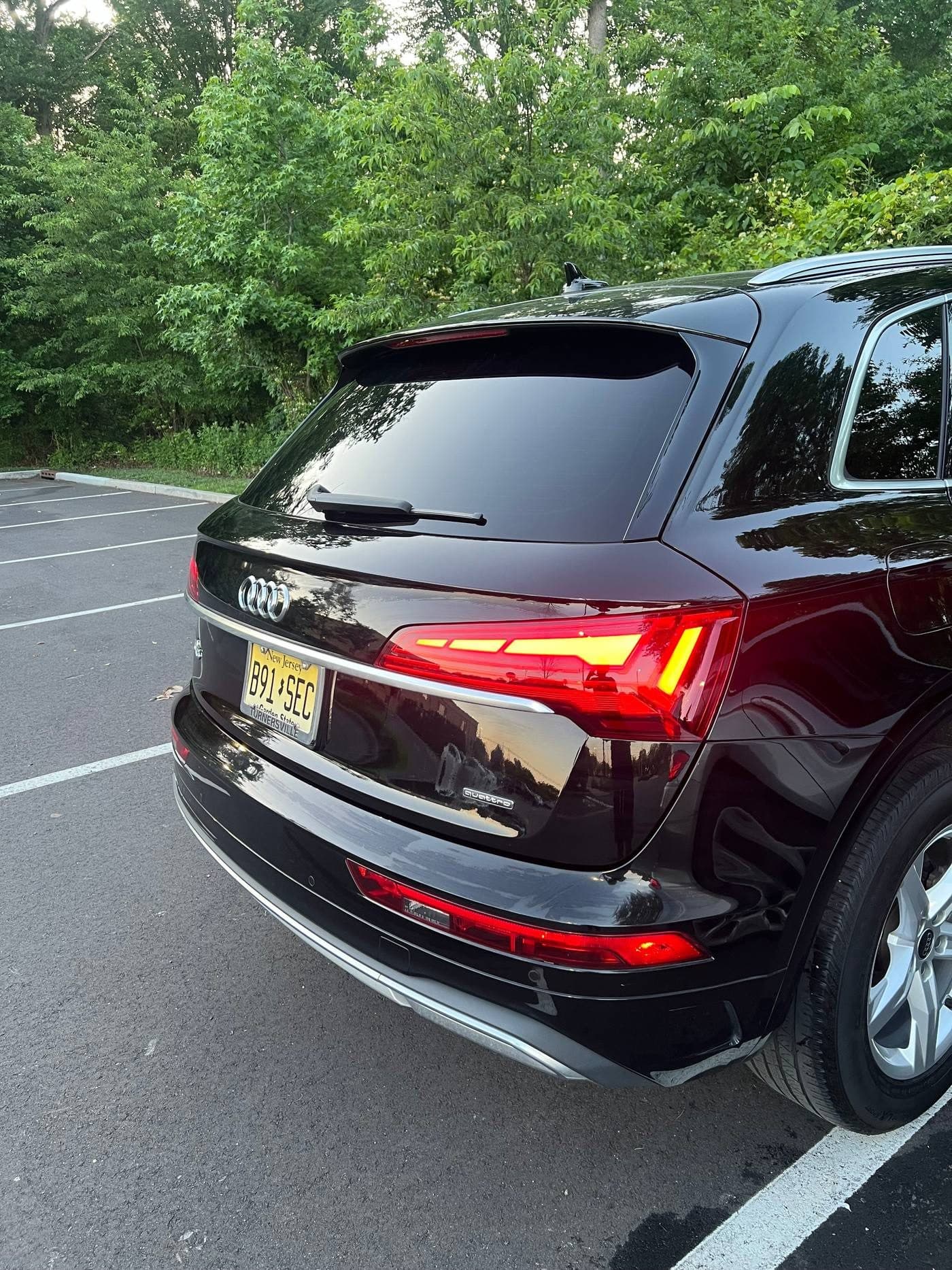 Glossy dark maroon Audi Q5 rear exterior with glowing red tail lights