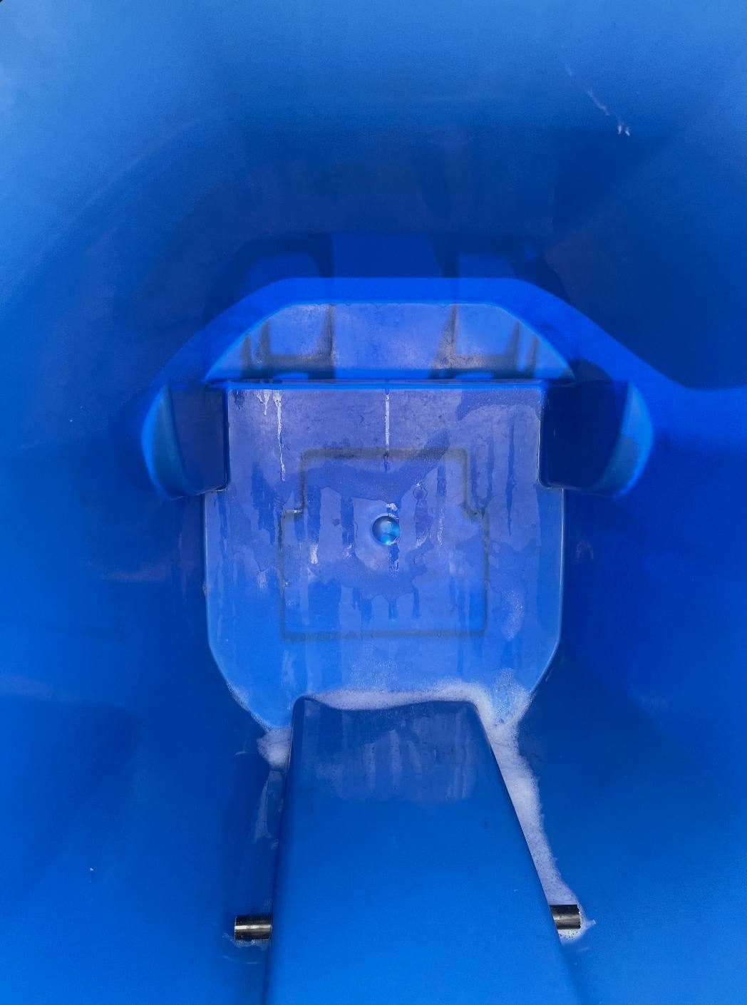 Inside of a trash bin sparkling clean with soap suds after cleaning
