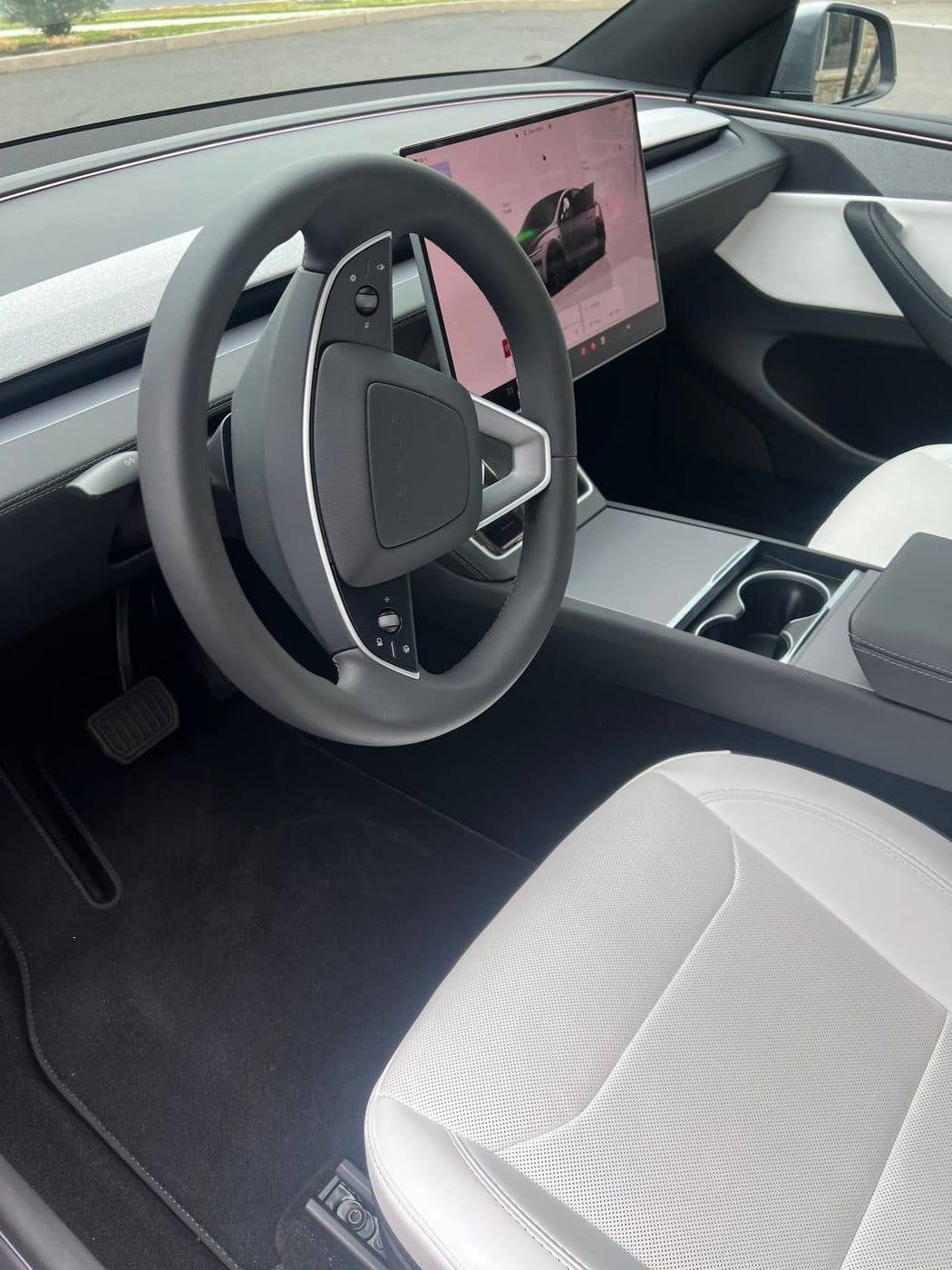 Clean Tesla Model Y interior after detailing — spotless white seats and black carpet